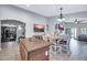 Open living area with island seating, wall-mounted TVs, and sight lines to dining area at 4232 S 103Rd Ln, Tolleson, AZ 85353