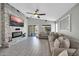 Inviting living room with a stone fireplace, ceiling fan, and large sectional sofa at 4232 S 103Rd Ln, Tolleson, AZ 85353