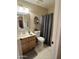 Functional bathroom featuring wood cabinet, neutral walls, vanity mirror, and a gray shower curtain, offering comfort and style at 426 W Pontiac W Dr # 4, Phoenix, AZ 85027