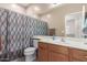 Well-lit bathroom with a vanity, toilet, and a shower-tub combination with a curtain at 45028 W Cypress Ln, Maricopa, AZ 85139