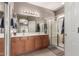 Bathroom showcasing double sinks, a large mirror, and a glass-enclosed shower at 45028 W Cypress Ln, Maricopa, AZ 85139