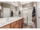 Bathroom featuring double sinks, a large mirror, and a glass-enclosed shower at 45028 W Cypress Ln, Maricopa, AZ 85139