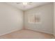Bright, empty bedroom with neutral carpet flooring and a window providing natural light at 45028 W Cypress Ln, Maricopa, AZ 85139