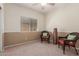 Cozy bedroom with two wicker chairs, natural light, and neutral carpet flooring at 45028 W Cypress Ln, Maricopa, AZ 85139