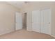 Bright bedroom featuring neutral carpeting, closet, and an open doorway leading to another room at 45028 W Cypress Ln, Maricopa, AZ 85139