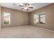 Bright bedroom with two windows providing natural light and neutral carpet at 45028 W Cypress Ln, Maricopa, AZ 85139