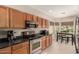 Functional kitchen featuring wood cabinets, stainless steel appliances, and a cozy breakfast nook at 45028 W Cypress Ln, Maricopa, AZ 85139