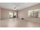 Spacious living room with tile floors, a ceiling fan, and sliding glass doors to the outdoor patio at 45028 W Cypress Ln, Maricopa, AZ 85139