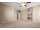 Spacious main bedroom with neutral carpet, ceiling fan, and ensuite bathroom access at 45028 W Cypress Ln, Maricopa, AZ 85139