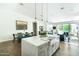 Spacious kitchen island with farmhouse sink and modern faucet, complemented by elegant pendant lighting and dining area at 4817 N 35Th St, Phoenix, AZ 85018