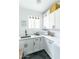 Well-lit laundry room with white cabinets, black hardware, modern appliances, and a sink at 4817 N 35Th St, Phoenix, AZ 85018
