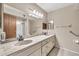 Bright bathroom featuring double sinks with marble countertops and grab bars for accessibility at 5126 W Las Palmaritas Dr, Glendale, AZ 85302