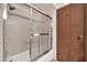 Bathroom featuring a tiled shower with glass doors and tiled walls for easy maintenance at 5126 W Las Palmaritas Dr, Glendale, AZ 85302