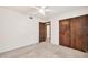 Carpeted bedroom boasts a ceiling fan, ensuite bathroom, and closet at 5126 W Las Palmaritas Dr, Glendale, AZ 85302