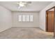 Bright bedroom features a ceiling fan, window with plantation shutters, and an ensuite bathroom at 5126 W Las Palmaritas Dr, Glendale, AZ 85302