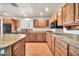 Spacious kitchen with a center island, granite countertops, and wooden cabinets at 5126 W Las Palmaritas Dr, Glendale, AZ 85302