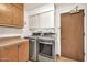 Functional laundry room featuring modern washer and dryer and ample cabinet space at 5126 W Las Palmaritas Dr, Glendale, AZ 85302