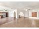 Spacious living room with tile floors, arched doorways, and a view of the kitchen and front entryway at 5126 W Las Palmaritas Dr, Glendale, AZ 85302