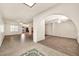 Open-concept living space with tile flooring, skylight, and seamless transition to adjoining rooms via arched doorways at 5126 W Las Palmaritas Dr, Glendale, AZ 85302