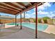 Covered outdoor patio with wood beams overlooks pool and backyard at 5126 W Las Palmaritas Dr, Glendale, AZ 85302