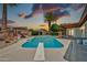 Backyard swimming pool with diving board and covered patio area surrounded by landscaping at sunset at 5126 W Las Palmaritas Dr, Glendale, AZ 85302