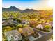 Scenic aerial view of the residential community with picturesque mountain backdrop at sunset at 5231 W Desperado Way, Phoenix, AZ 85083