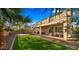 Backyard with artificial turf, mature palms, covered patio with furniture, and a basketball hoop at 5231 W Desperado Way, Phoenix, AZ 85083