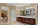 Bathroom showcasing vanity with dual sinks, elegant mirror, and separate door for toilet area at 5231 W Desperado Way, Phoenix, AZ 85083