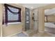 Modern bathroom featuring a glass-enclosed shower with stylish tile and sleek fixtures, adjacent to main bedroom at 5231 W Desperado Way, Phoenix, AZ 85083