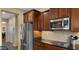 Kitchen showcasing stainless steel appliances, dark wood cabinets, and tile backsplash at 5231 W Desperado Way, Phoenix, AZ 85083