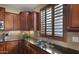 A bright, eat-in kitchen showcases granite countertops, dark wood cabinets, and stainless steel faucet at 5231 W Desperado Way, Phoenix, AZ 85083