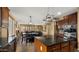 Open-concept kitchen features dark wood cabinets, island with granite countertops, and stainless steel appliances at 5231 W Desperado Way, Phoenix, AZ 85083
