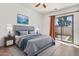 Serene bedroom with a queen-sized bed, soft lighting, hardwood floors, and a sliding glass door to a private patio at 544 N Alma School Rd # 28, Mesa, AZ 85201