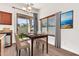 Cozy dining area with a wooden table, four chairs, modern light fixture, and a view of the backyard at 544 N Alma School Rd # 28, Mesa, AZ 85201