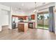Well-lit kitchen featuring stainless steel appliances, a kitchen island, cherry wood cabinets, and a sliding glass door at 544 N Alma School Rd # 28, Mesa, AZ 85201