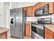 Modern kitchen featuring stainless steel appliances, dark wood cabinets, and ample counter space for meal preparation at 544 N Alma School Rd # 28, Mesa, AZ 85201