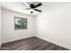 Light, bright bedroom offers wood-look floors, ceiling fan, and window overlooking the neighborhood at 632 N 95Th St, Mesa, AZ 85207