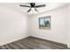 Neutral bedroom featuring a ceiling fan, wood-look floors, and a window with neighborhood views at 632 N 95Th St, Mesa, AZ 85207