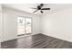 Bright bedroom features modern ceiling fan, wood-look floors, and sliding glass door to the backyard at 632 N 95Th St, Mesa, AZ 85207