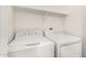 Bright laundry area featuring white appliances and overhead shelving at 632 N 95Th St, Mesa, AZ 85207