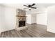 Living room with a stone fireplace and gray wood-look flooring, offering a cozy and modern feel at 632 N 95Th St, Mesa, AZ 85207