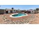 Backyard boasts a private pool surrounded by rock landscaping and various backyard structures at 632 N 95Th St, Mesa, AZ 85207