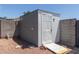 Exterior of a gray and white shed with a white door and ramp. Gravel ground at 632 N 95Th St, Mesa, AZ 85207