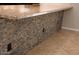 Close-up showcasing the kitchen island's stone accents, granite countertop, and electrical outlets at 749 N 99Th St, Mesa, AZ 85207