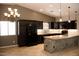Modern kitchen features dark cabinets, granite countertops, and a stylish stone-clad breakfast bar at 749 N 99Th St, Mesa, AZ 85207
