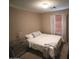 Bedroom featuring a bed, side table, and window with blinds at 7521 S 31St Pl, Phoenix, AZ 85042