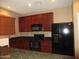 Kitchen showcasing black appliances, granite countertops, and cherry wood cabinets under recessed lighting at 7521 S 31St Pl, Phoenix, AZ 85042