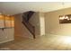 Open-concept living room featuring neutral tile floors, a staircase, and a view into other rooms at 7521 S 31St Pl, Phoenix, AZ 85042