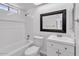 A bathroom with a tub, toilet, and vanity featuring bright tilework and modern fixtures at 7614 W Cheery Lynn Rd, Phoenix, AZ 85033