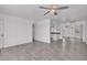 Open-concept living room with wood-look tile flooring, ceiling fans and kitchen view at 7614 W Cheery Lynn Rd, Phoenix, AZ 85033